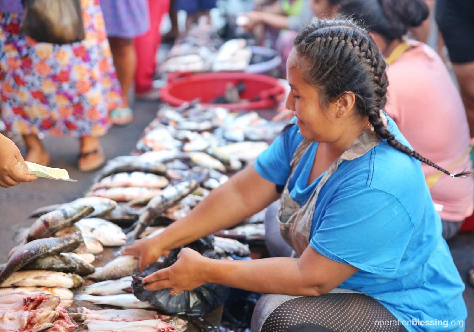 Nadia rises early each morning to sell the fish her husband catches to earn money for their family.